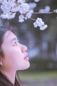 Side view of young woman with flowers