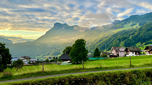 Scenic view of houses and mountains against sky