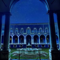 Low angle view of illuminated building against blue sky