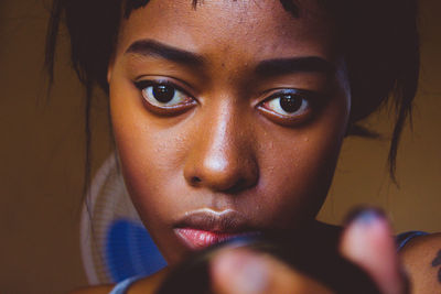 Close-up portrait of serious woman at home