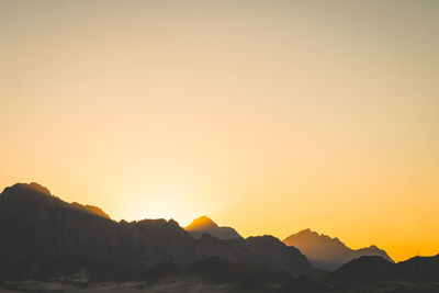 Scenic view of silhouette mountains against sky during sunset