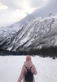 Man on snow covered mountain against sky