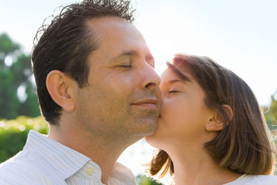 Close-up portrait of couple kissing outdoors