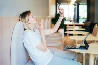 Young woman using mobile phone at home