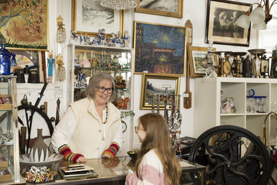 Grandmother and granddaughter doing shopping in antique shop
