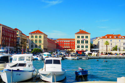 Boats in sea against buildings in city