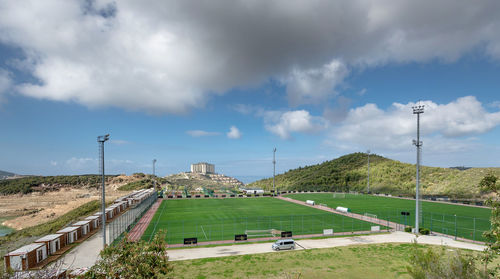 Scenic view of grassy soccer field against cloudy sky