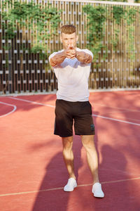 Full length of young man playing tennis