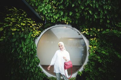 Woman standing against plants