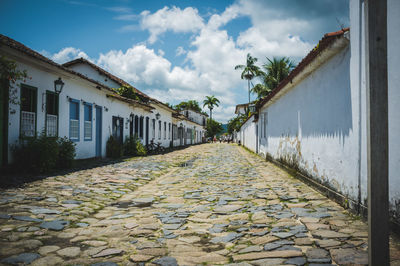 Surface level of footpath amidst buildings against sky