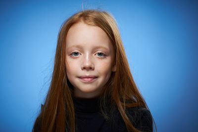 Close-up of young woman against blue background