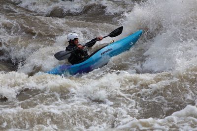 Man surfing on boat in river