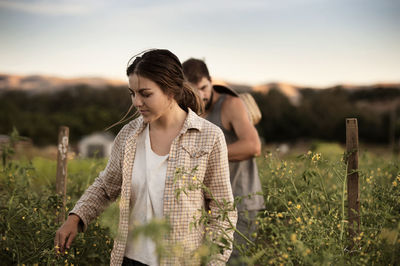 Male and female farmers working on field