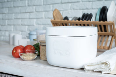 Kitchen appliances and devices. electric smart rice cooker on wooden counter-top in the kitchen