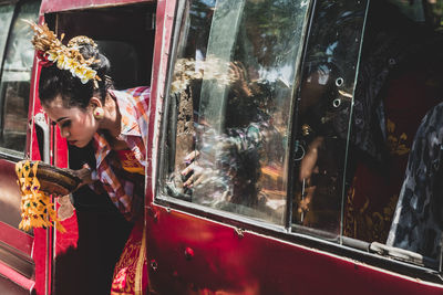 Woman looking through window at store