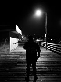 Full length rear view of man standing at night