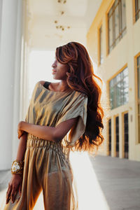 Young female model posing against building