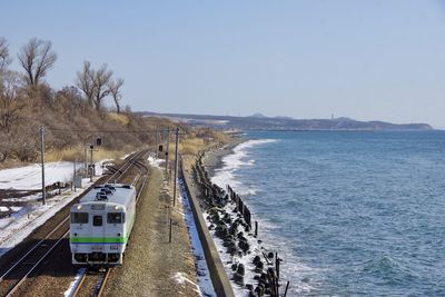 High angle view of road by sea against clear sky