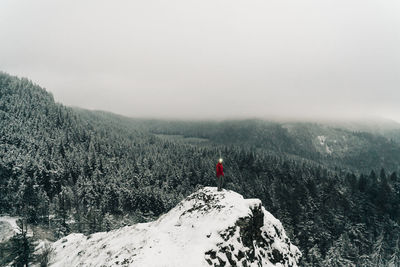 A young woman stands on the top of a snowy point in the columbia gorge