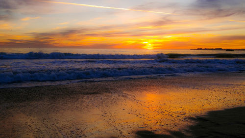 Scenic view of beach against sky during sunset