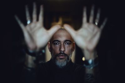 Portrait of man wearing mask against black background