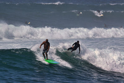 Men surfing in sea