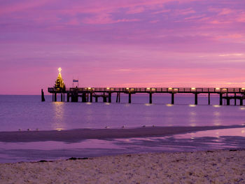 Pier over sea against sky during sunset