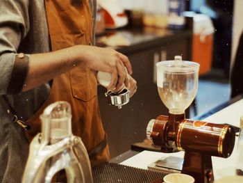 Midsection of man preparing coffee at cafe