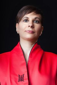 Portrait of woman wearing kimono standing against black background