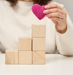 Midsection of woman with toy blocks on table