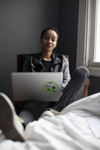 Portrait of a smiling young woman using laptop