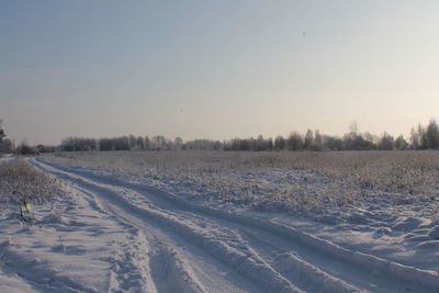 Snow covered landscape against clear sky