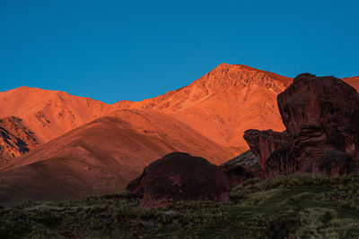 Scenic view of mountains against clear blue sky