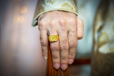 Close-up of man wearing gold ring