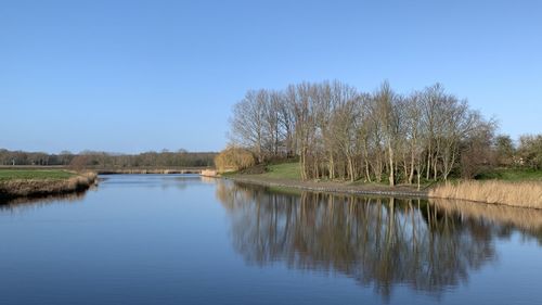 Scenic view of lake against clear blue sky