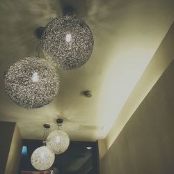 Low angle view of illuminated chandelier hanging from ceiling