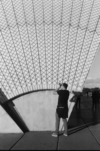 Rear view of people walking on bridge in city