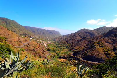 Scenic view of mountains against blue sky