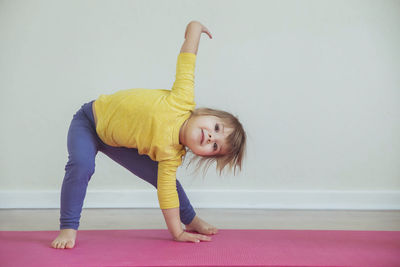 Charming baby doing yoga at home. place for text