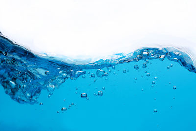 Close-up of frozen sea against blue sky