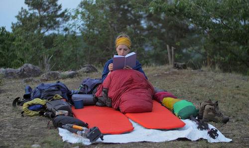 Woman reading book in camp