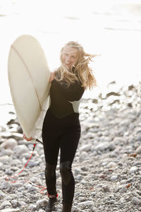 Woman with surfboard on beach