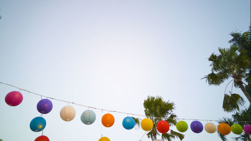 Low angle view of colorful lanterns hanging against clear sky