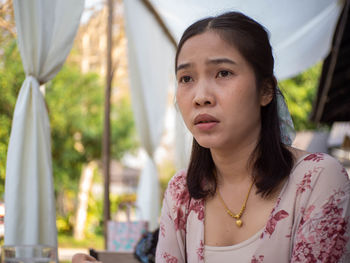 Portrait of young woman looking away outdoors