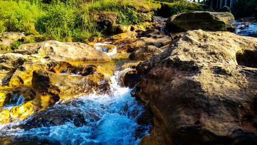 View of stream flowing through rocks