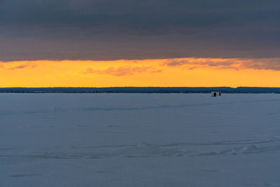 Scenic view of snow covered land during sunset