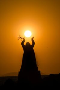 Silhouette of woman at sunset