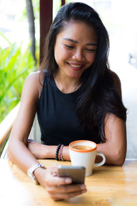 Portrait of young woman sitting on table