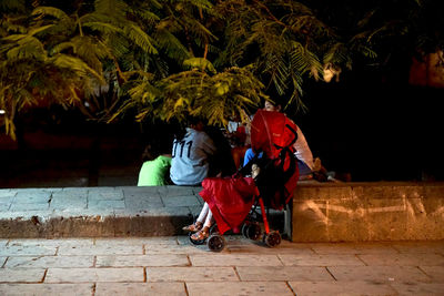 Rear view of people walking on street at night