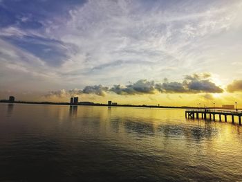 Silhouette bridge over water against sky during sunset